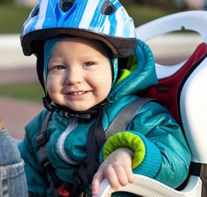Child in a bike seat with helmet