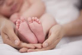 Newborn baby feet in woman's hands