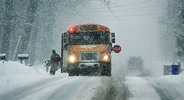 Snow covered street and a school bus